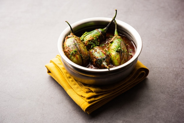 Brinjal curry also known as spicy baingan or eggplant masala, a popular main course recipe from India served in a bowl, karahi or pan