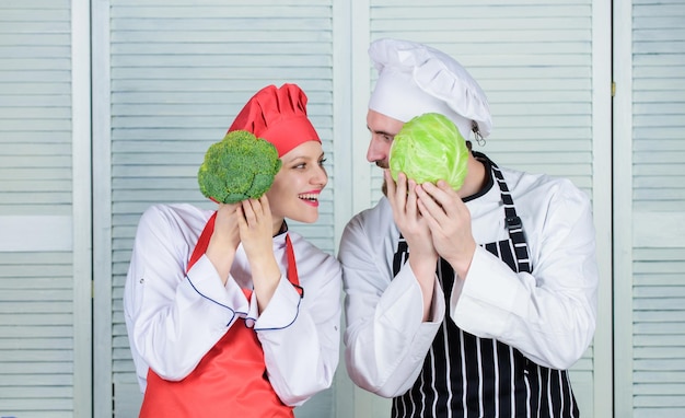 Broccoli and cabbage Chef prepares meal man and woman chef in restaurant vegetarian cook Family cooking in kitchen happy couple in love with healthy food Dieting and vitamin culinary cuisine