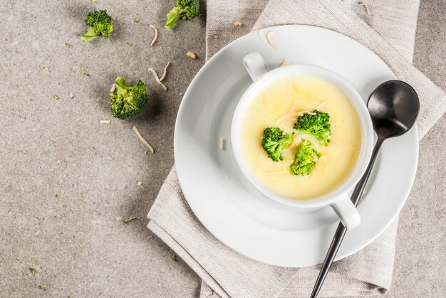 Photo broccoli, cheese and chicken soup, on gray stone table,  top view