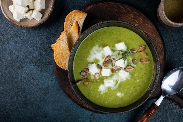 Broccoli cream soup in a bowl with toasted bread and cheese