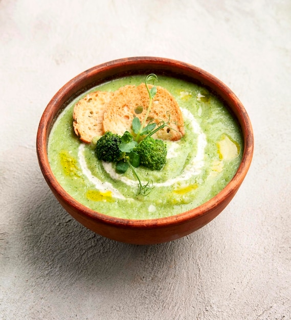 Broccoli puree soup with crackers and fresh vegetables on the tables Homemade cookingVegetarian food