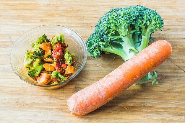 Broccoli salad with carrot in glass bowl