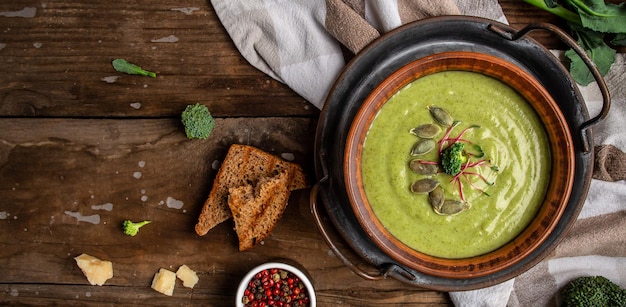 Broccoli soup on bowl on wooden background Vegan soup puree of green vegetables Vegetarian and diet food