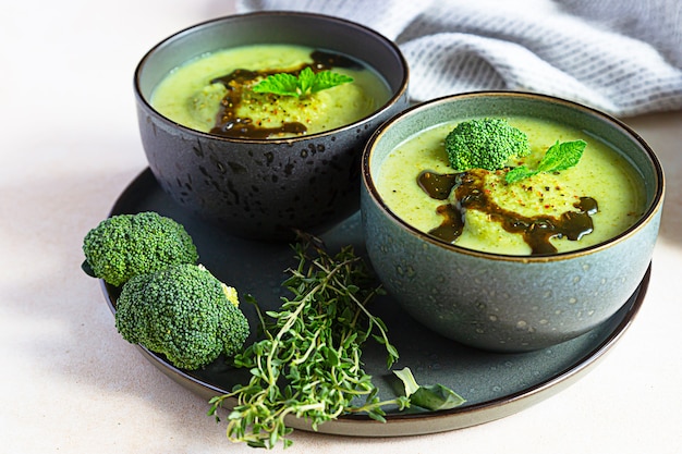 Broccoli or spinach green soup with aromatic spicy oil in bowl. Vegan healthy food.