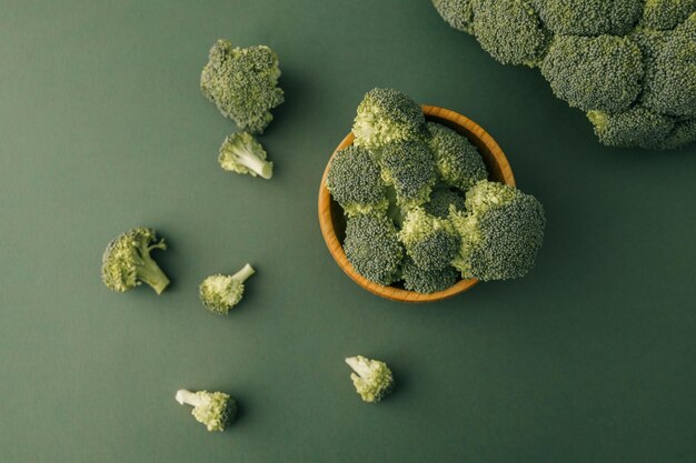 Photo broccoli in a wooden bowl on a green background