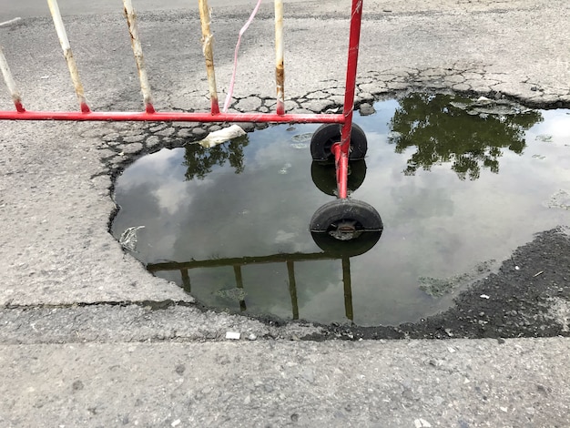 Broken asphalt road with water, No passing zone