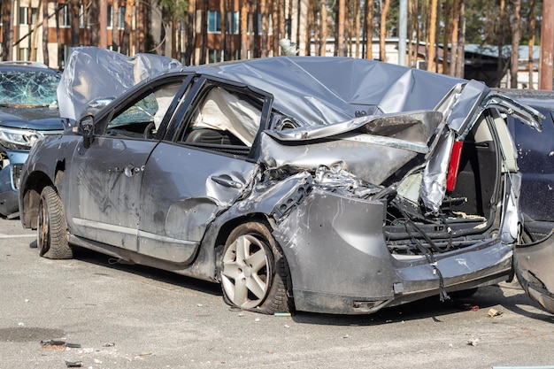 Broken car after a traffic accident in the parking lot of a repair station Car body damage workshop