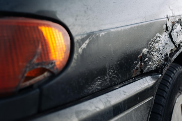 A broken car headlight with traces of repair Selective focus on the fender of the car