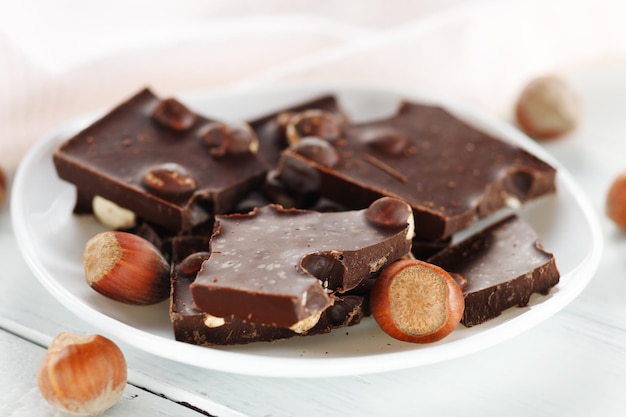 Broken chocolate with nuts in a white plate