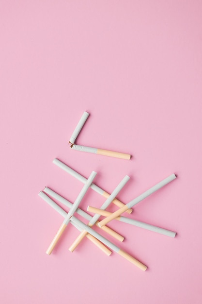 Broken cigarette on a pink background