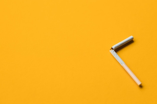 Broken cigarette on a yellow background No smoking concept