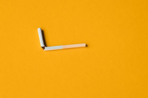 Broken cigarette on a yellow background No smoking concept