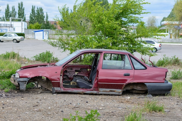 Broken, crumpled, dented car after the accident. Abandoned wrecked cars. Dump of wrecked cars. Broken auto after an accident.