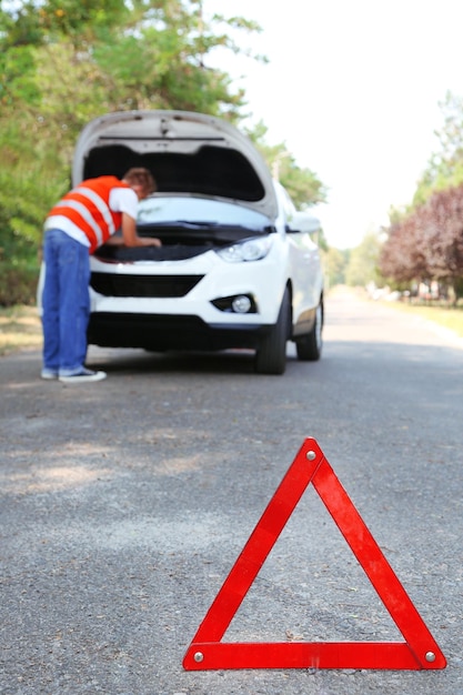 Broken down car with red warning triangle