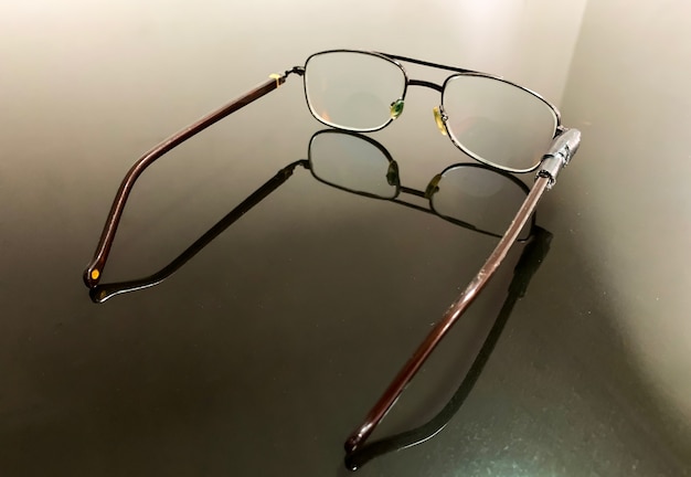 Broken eyeglasses on glass table, shallow focus