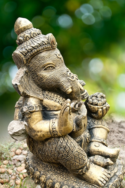 A Broken Ganesha Statue on Green Background