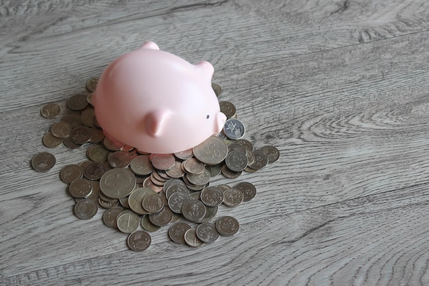 Broken piggy bank and coins on wooden table with copy space Financial concept