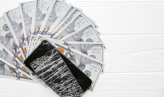 Broken screen protector tempered glass Money lying near the phone Dollar notes