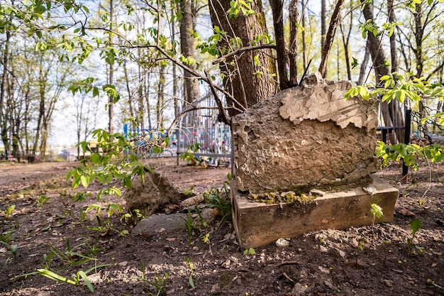 Broken tombstone on an abandoned grave in a cemetery on a spring day