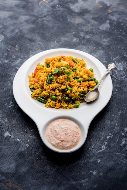 Broken wheat or Daliya Upma, served in a bowl. selective focus