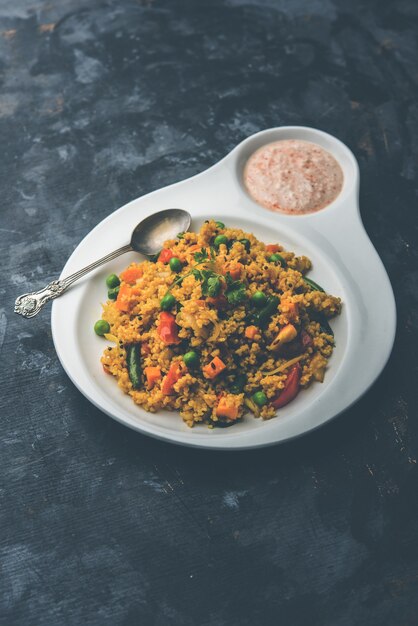 Broken wheat or Daliya Upma, served in a bowl. selective focus