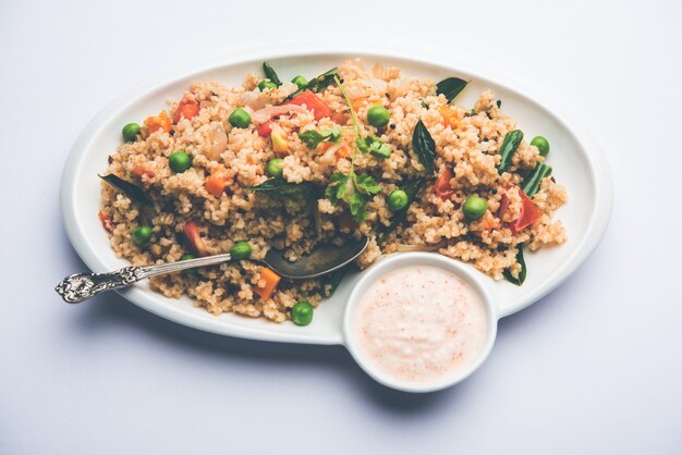 Photo broken wheat or daliya upma, served in a bowl. selective focus