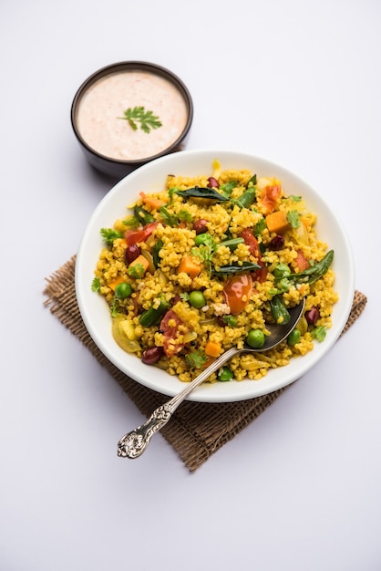 Broken wheat or Daliya Upma, served in a bowl. selective focus