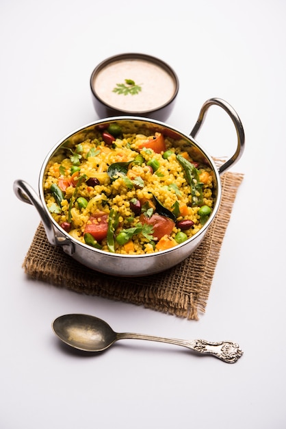 Broken wheat or Daliya Upma, served in a bowl. selective focus