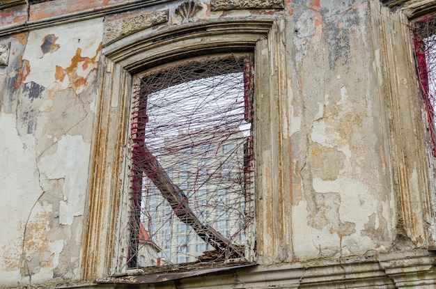 A broken window in the wall of an old house.