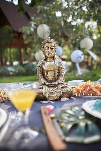 Photo bronze buddha figurine in nature at a picnic closeup of the buddha figurine