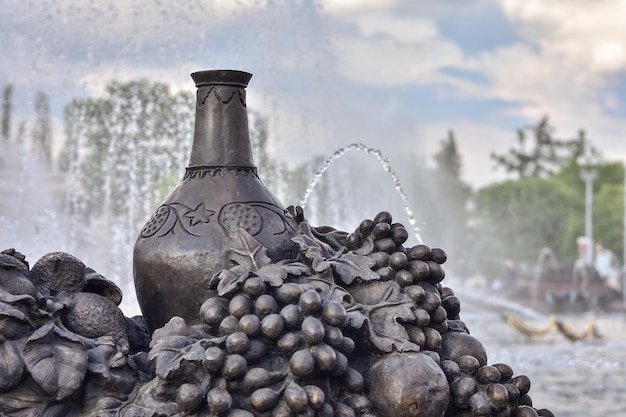 Bronze decanter and grapes at the fountain