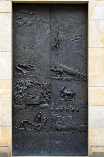 A bronze door with a picture of a farm and a horse on it.