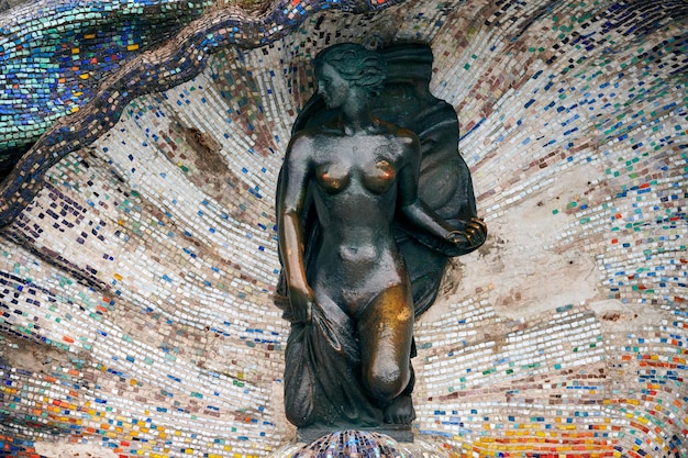 Bronze sculpture of Nymph girl in mosaic seashell at seaside beautiful statue of nude girl