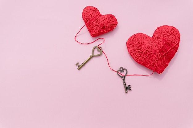 Bronze skeleton key and pink knitted heartsantique rustic keys on pink background Happy valentine's day cardsymbol of love Hobby conceptheartbeatfeelings romance conceptCopy space