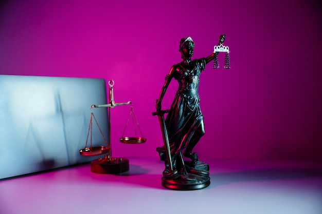 Bronze statue Lady Justice holding scales and sword in notary office.