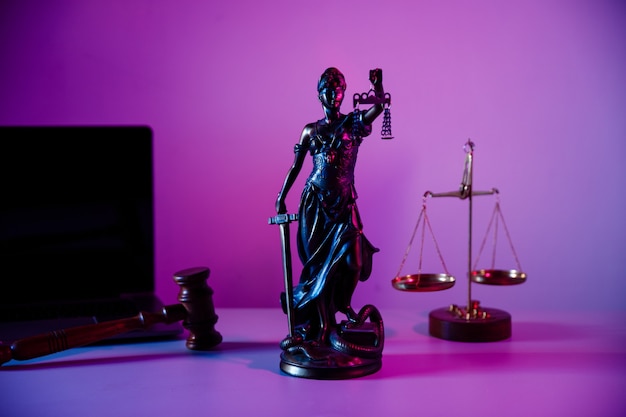 Bronze statue lady justice with scales in notary office on purple background