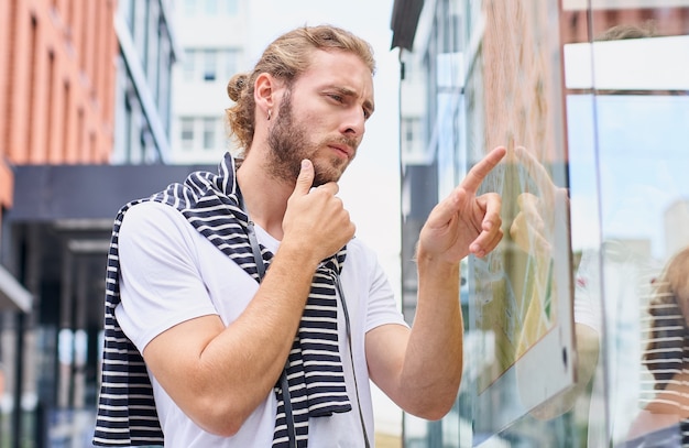 A brooding Caucasian man studies a map of the city a tourist