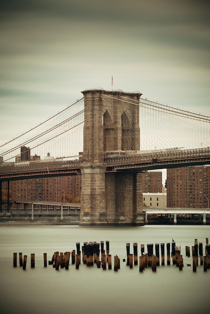 Brooklyn Bridge and abandoned pier ruins in East River.