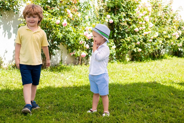 Brother child smiling at walk Children outdoor in spring park Funny kids