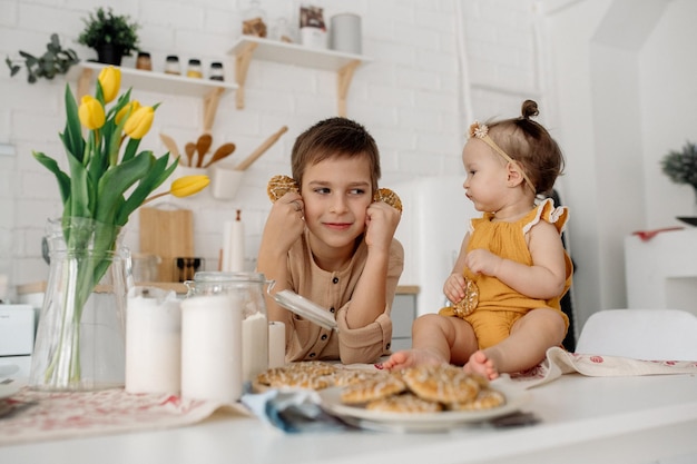 Brother and little sister are hugging in the kitchen Family life at home