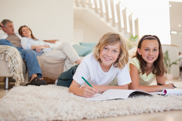 Brother and sister doing homework on the floor