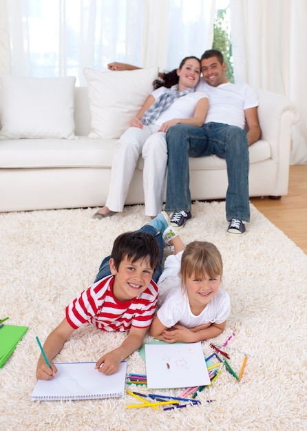 Brother and sister painting on floor in living-room