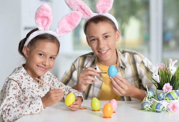 Brother and sister painting traditional Easter eggs