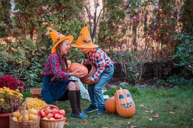 Brother and sister play in the Autumn Garden surrounded by fruits of vegetables and fruits