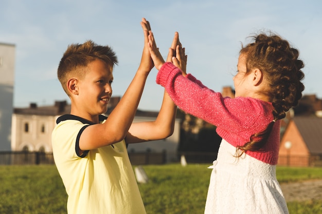 Brother and sister play outdoors in summer.