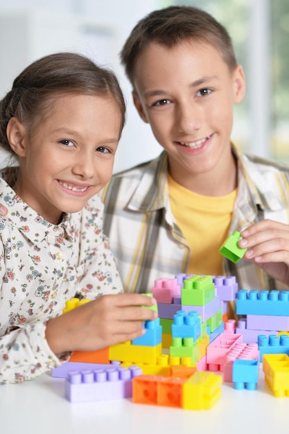 Brother and sister playing with plastic blocks