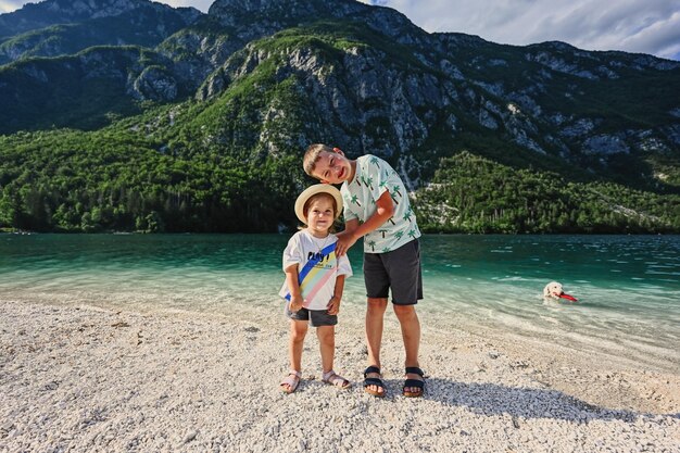 Brother with sister and dog against Lake Bohinj the largest lake in Slovenia part of Triglav National Park