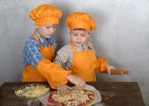 brothers help mom to cook pizza with sausage and cheese