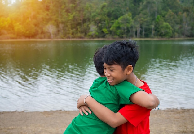 Brothers hug each other by the reservoir in the evening