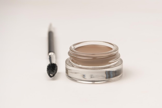 A brow pomade in blonde shade with brush isolated on a white background